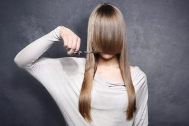 vrouw met lange pony en schaar