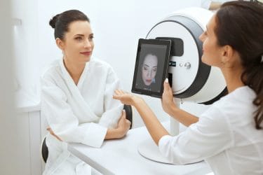 skin expert heeft een huidanalyse apparaat gebruikt voor het analyseren van de huid van een klant.