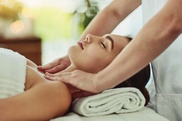 massagetherapeut masseert decolleté en schouders van klant