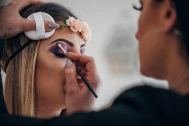 Student van de opleiding make-up artist werkt aan een creatie.