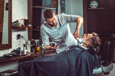 man laat zijn baard verzorgen in een barbershop