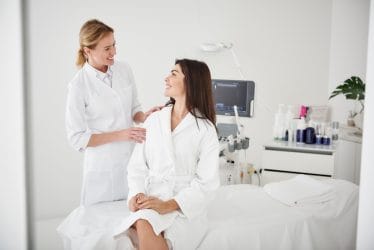 Professionele schoonheidsspecialiste praat met klant.