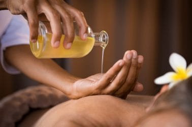 Massagetherapeut gaat massage geven met aromatische massageolie om een winterdip weg te masseren..