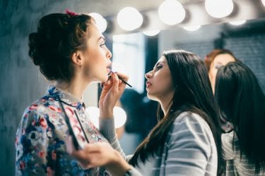 Jonge vrouw oefent met make-up tijdens een van de creatieve visagie cursussen.